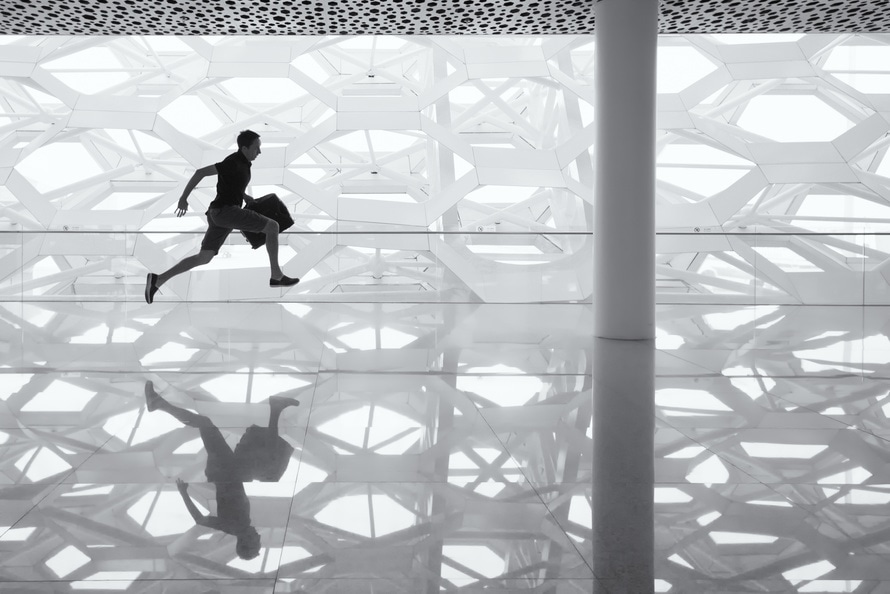 Man Running down glass hallway